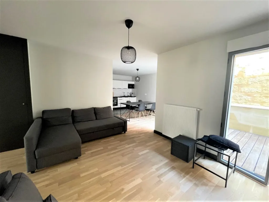 appartement vue du salon avec cuisine en fond et terrasse
